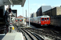 GMS1230C - View along the platform at Hammersmith station showing the car sheds and approaching train 21/4/93