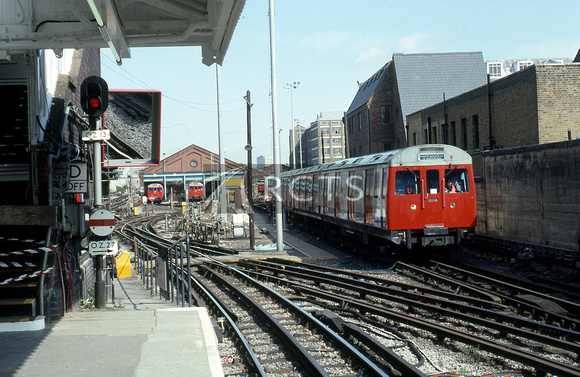 GMS1230C - View along the platform at Hammersmith station showing the car sheds and approaching train 21/4/93